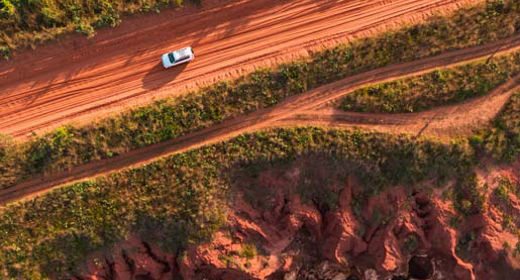 Auto fährt auf Weg mit roten Sand im australischen Outback