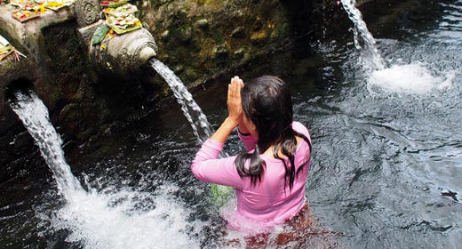 Frau betet im Tempel auf Bali